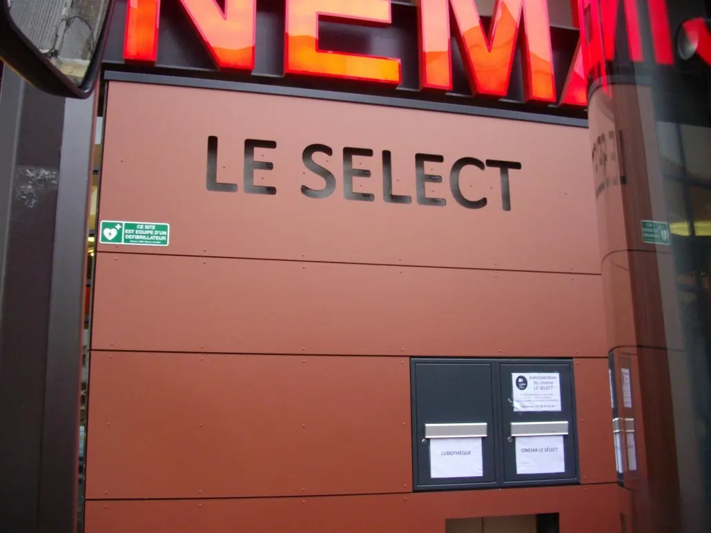 Bardage en panneaux de stratifié avec lettrage découpé sur la façade d'un cinéma