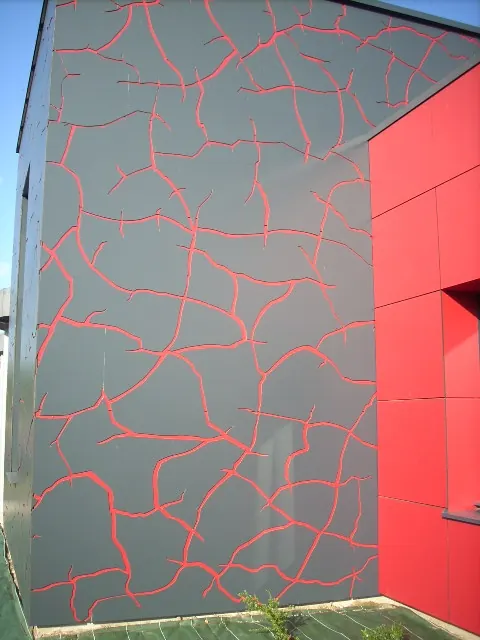 Façade en panneaux de stratifié gris à motif craquelé rouge